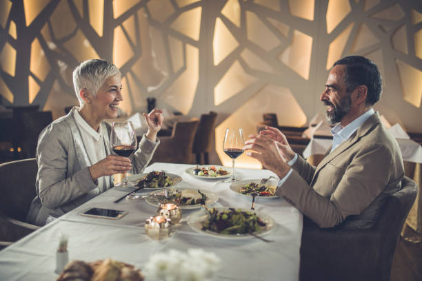 istock Happy mature couple having lunch in a restaurant and communicating. 925180512