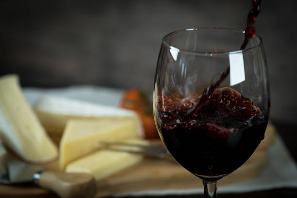 istock Red wine poured into a glass with cheese board 925183238