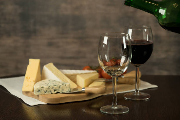 istock Red wine poured into a glass with cheese board 925183240