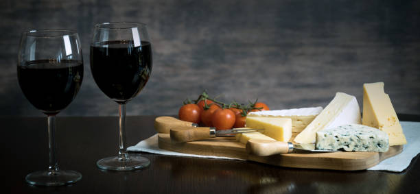 istock Red wine poured into a glass with cheese board 925183244