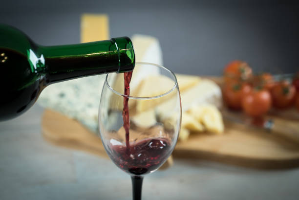 istock Red wine poured into a glass with cheese board 925183268