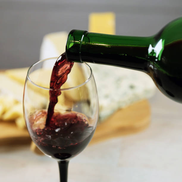 istock Red wine poured into a glass with cheese board 925183270