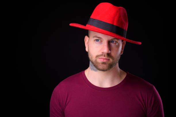 istock Young handsome bearded bald man with tattoos against black background 925185256