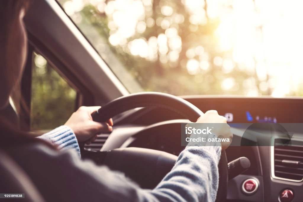 Woman driving car at sunny. Driving Stock Photo