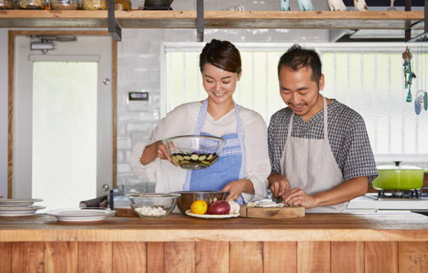 台所でカップル切削食材。 - mid adult couple ストックフォトと画像