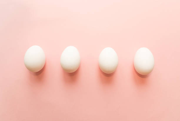 istock Four white eggs on pink pastel background. minimal concept. top view 925199528