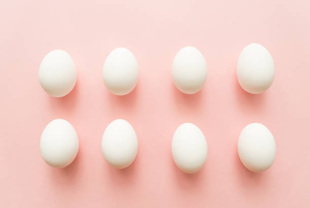istock A lot of white eggs on pink pastel background. minimal concept. top view 925199570