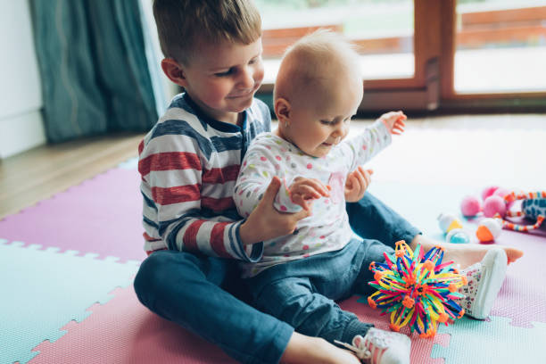 istock Cute little children playing while sitting on carpet 925202572