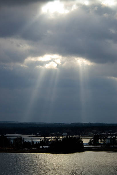 rays of sun over water and land stock photo