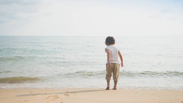 istock asian boy playing on the beach 925207056
