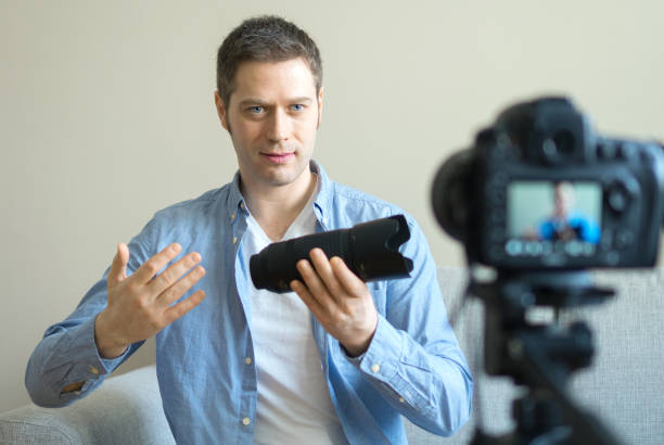 istock Handsome man making video blog about photo camera lenses. 925207882