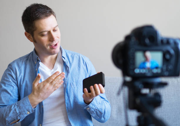 istock Handsome man making video blog about external hard drive. 925207908