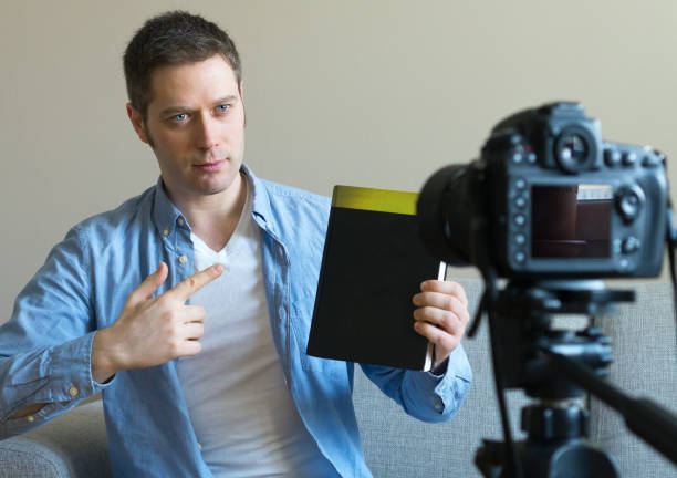 istock Handsome man making video blog about books and education. 925207910