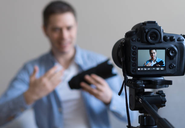 istock Man making video blog about photo camera lenses. Focus on camera. 925207918