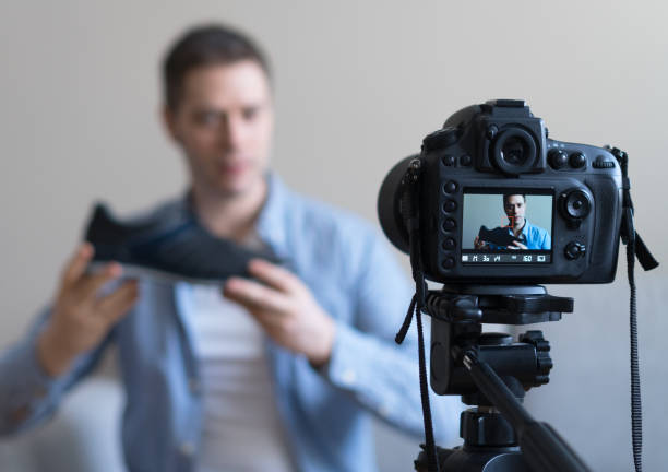 istock Man making video blog about shoes. Focus on camera. 925207928