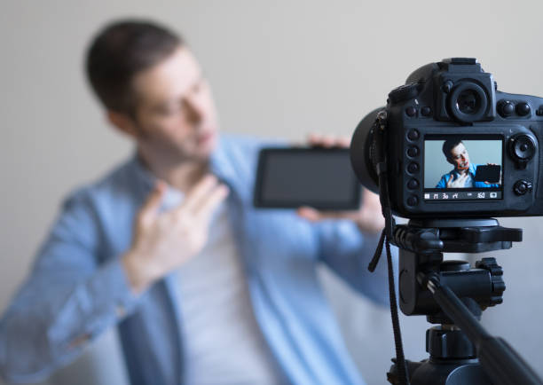 istock Man making video blog about tablet pc. Focus on camera. 925207958