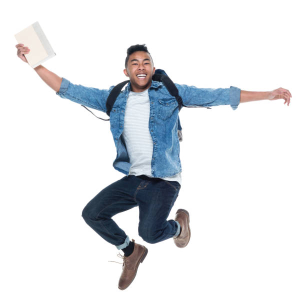 istock Handsome young male student with books and jumping 925210750