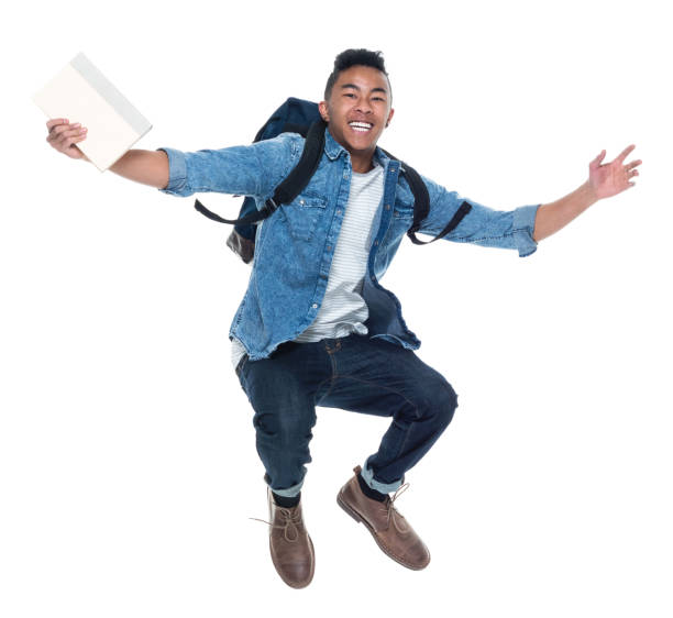 istock Handsome young male student with books and jumping 925210754