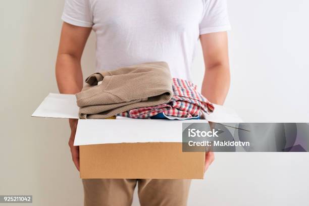 Uomo In Possesso Di Una Scatola Di Vestiti Dona Concetto Di Donazione - Fotografie stock e altre immagini di Abbigliamento