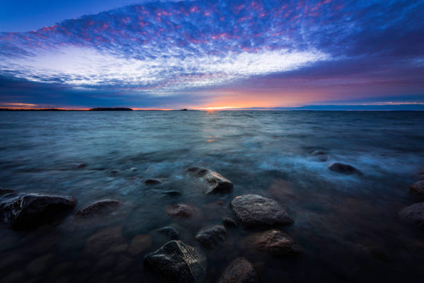 istock sunset on a rocky beach with waves rushing in 925211790