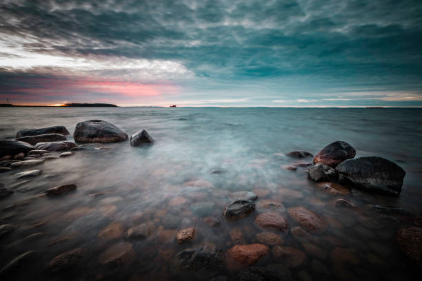 istock sunset on a rocky beach with waves rushing in 925211894
