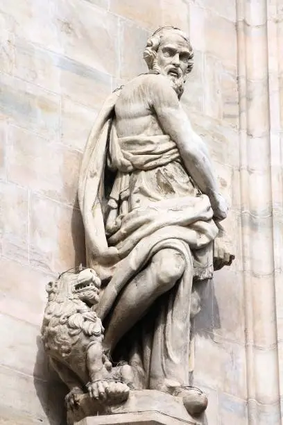 Saint Jerome (San Girolamo) sculpture with a lion. One of statues in the facade of Cathedral in Milan (Italy).