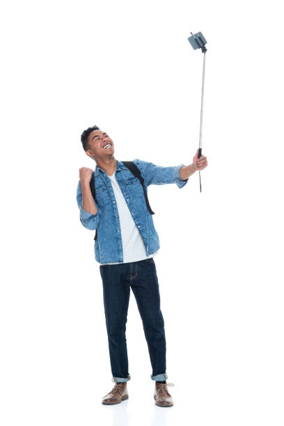 istock Attractive young male holding a selfie stick 925212430