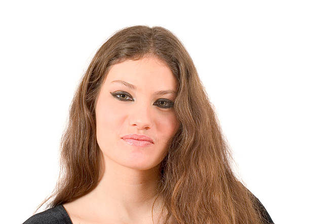 Outdoor image of concerned young Hispanic woman on college campus with grass background