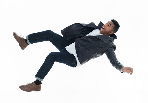 Daring young handsome male in mid air falling and jumping