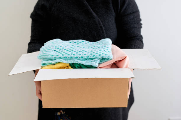 istock Man holding a clothes donate box. Donation concept. 925215852