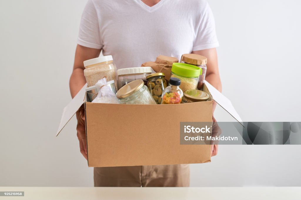 Volunteer with box of food for poor. Donation concept. Food Stock Photo