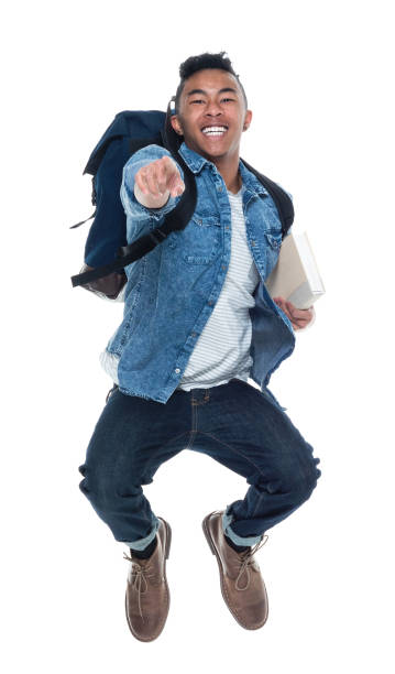 istock Handsome young male student with books and jumping 925219106