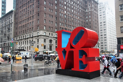 New York: People walk past Love sculpture in rain in New York. The famous monument by Robert Indiana is located on 6th Avenue.