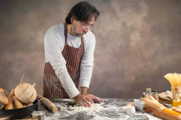 istock Chef hipster stylish kneads dough for bread on wooden board 925220094