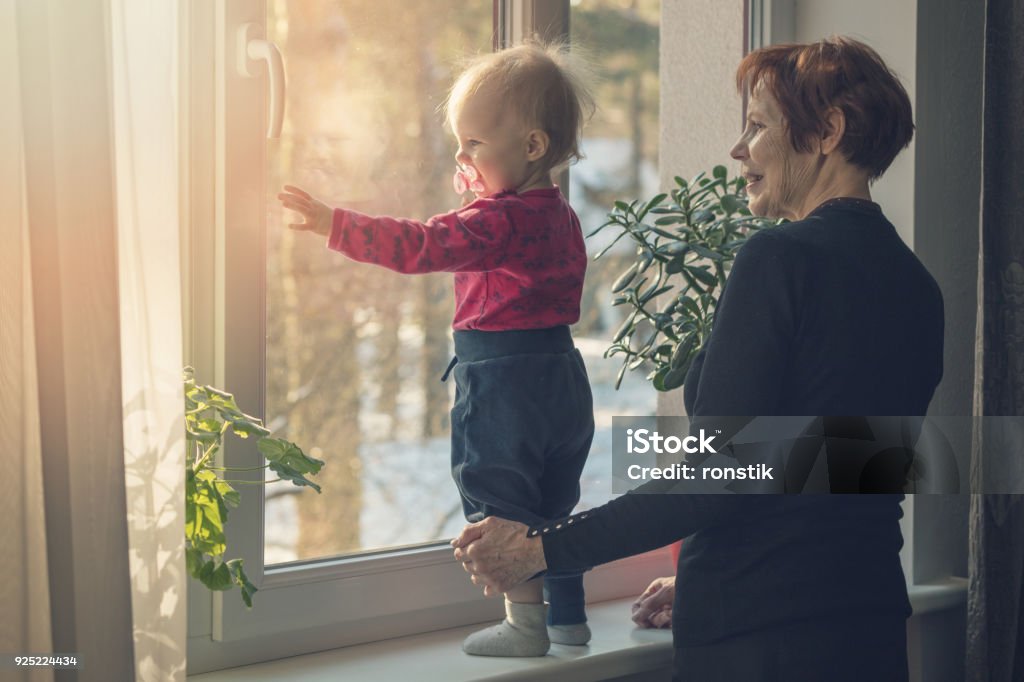 enfant et nounou, passer du temps ensemble à la maison regardant par la fenêtre - Photo de Enfant libre de droits