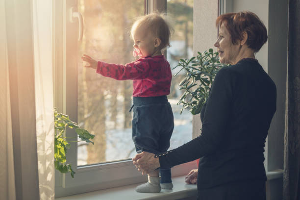 istock child and nanny spending time together at home looking through the window 925224434