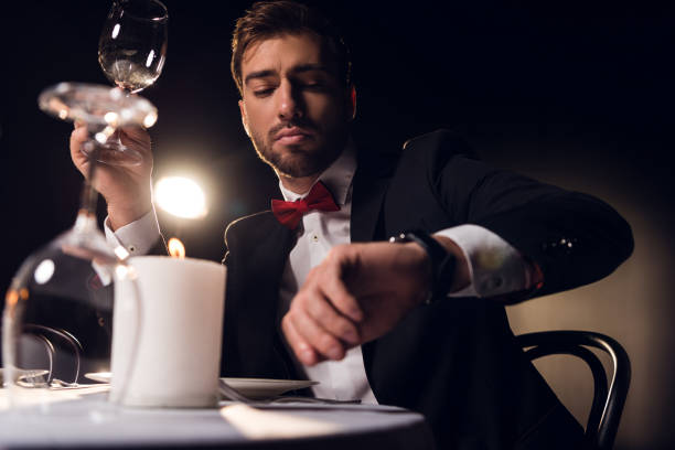 istock handsome bearded man looking at watch while waiting for romantic date in restaurant 925225516