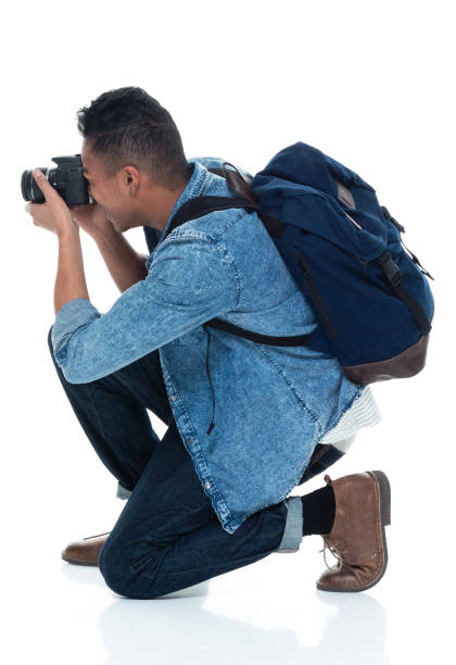 istock Young male photographer crouching and with camera 925225642