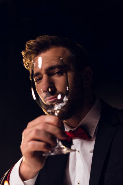 istock handsome bearded man looking through wine glass 925225754