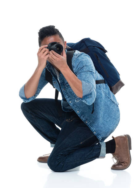 istock Young male photographer crouching and with camera 925230920