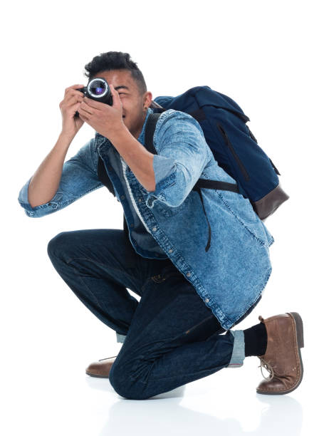 istock Young male photographer crouching and with camera 925232618