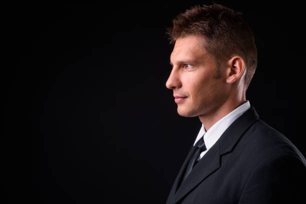 istock Handsome businessman against black background 925235588