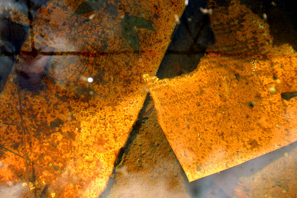 Water with a reflection on the lid of an old iron barrel with paint in the street. Blurry