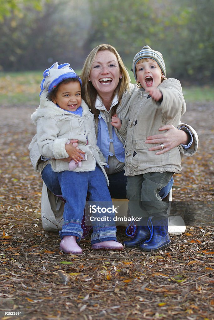 Mãe e duas crianças tendo diversão em família juntos no parque - Foto de stock de Família royalty-free