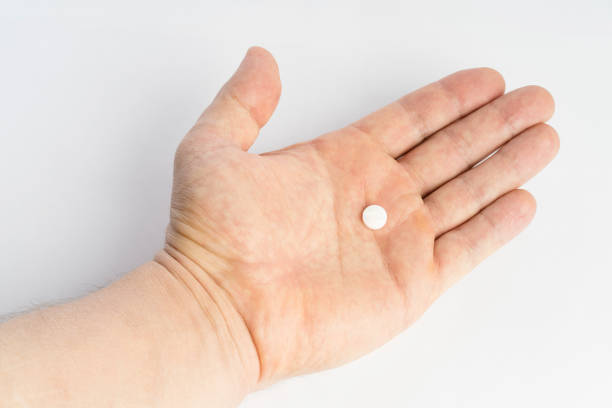 istock Open hand with one medicine tablet isolated on white background 925236862