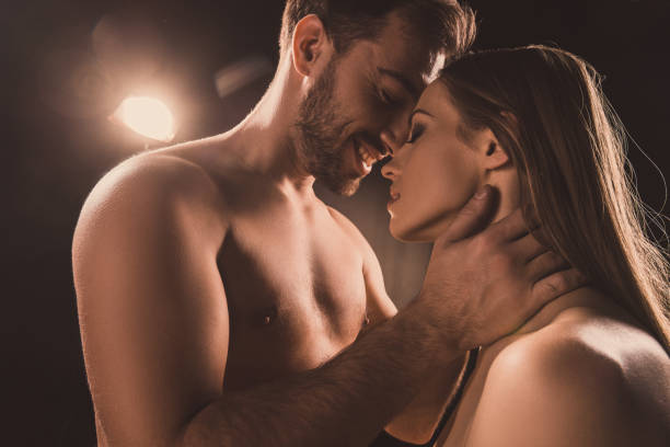 istock passionate couple hugging and smiling, on brown with back light 925236954