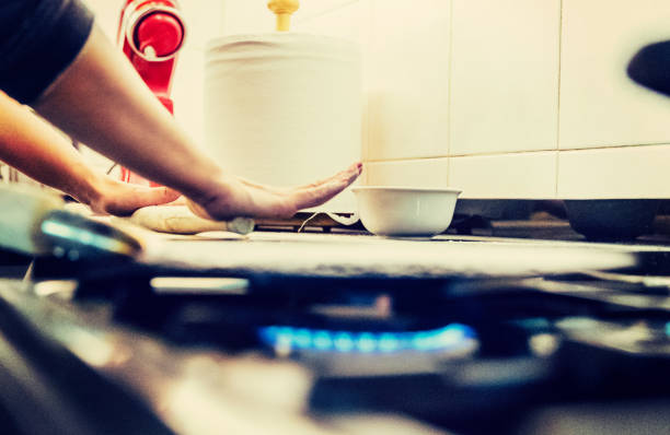 Housewife preparing rotis (chapatis) for dinner. With a messy counter to work with.