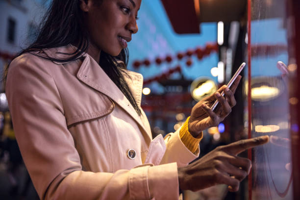 istock Woman using a touch screen finding informations online in London city streets 925239558