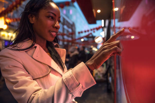 istock Woman using a touch screen finding informations online in London city streets 925239566