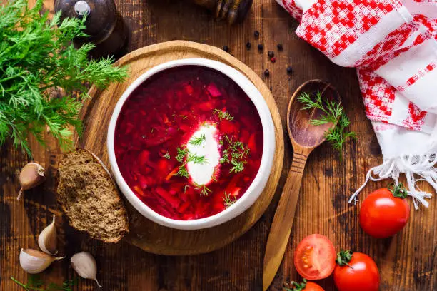 Borscht with sour cream - traditional Ukrainian and Russian beetroot soup. Rustic style. Table top view